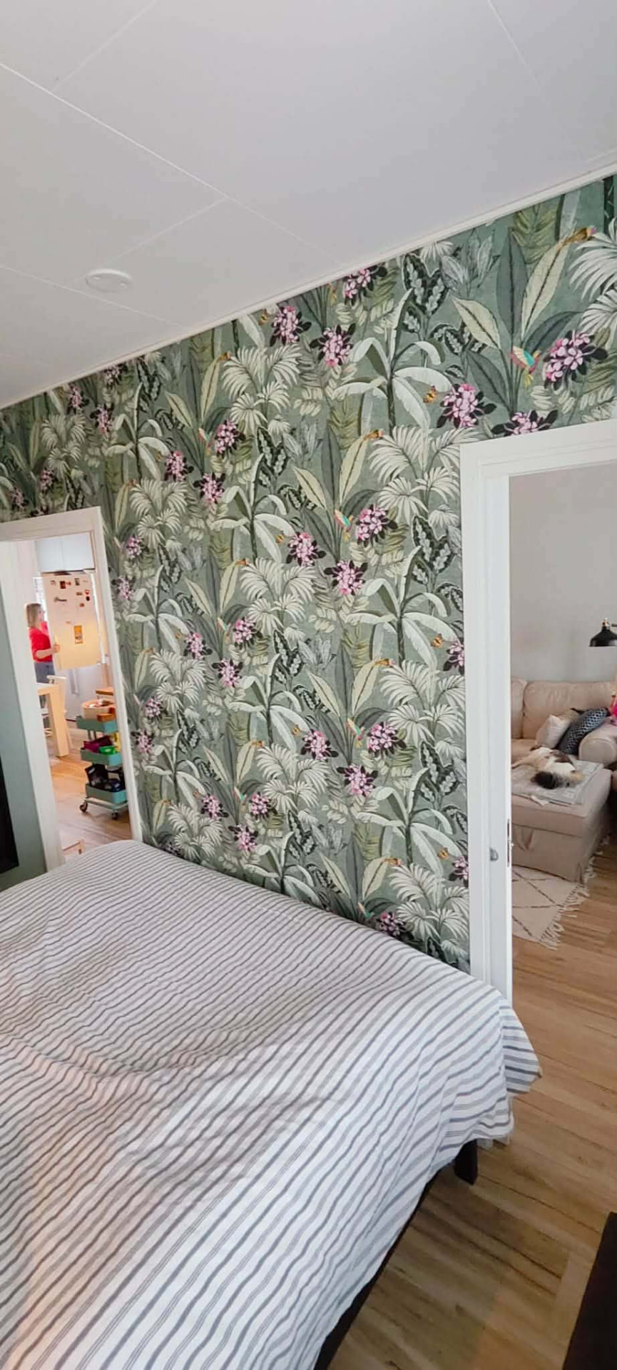 Tapetoitu seinä makuuhuoneessa kasviaiheisella tapetilla.